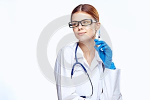 Young beautiful woman on white isolated background with glasses, doctor holding a syringe