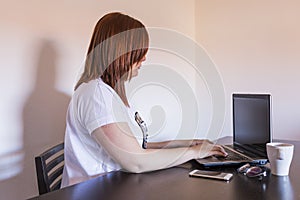 Giovane bella donna per affari sul computer portatile tazza da caffè, un taccuino. dentro. spazio 