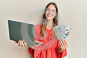 Young beautiful woman working at the office holding dollars smiling with a happy and cool smile on face