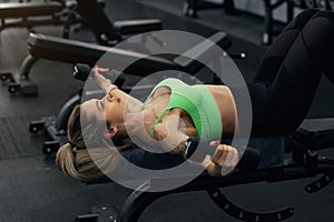 Young and beautiful woman working out with dumbbells in gym