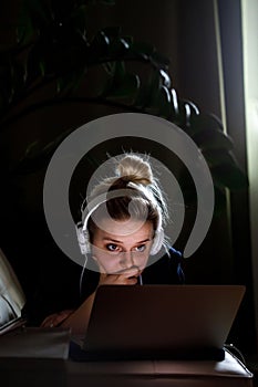 Young beautiful woman works for a computer from a home with a laptop as a freelancer