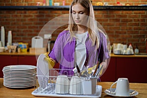 Young beautiful woman works in kitchen