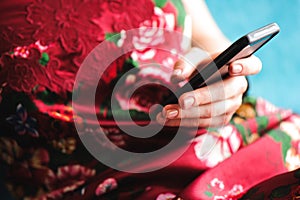 Young beautiful woman writes an SMS to her mobile phone.
