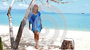 Young beautiful women in the blue tunic on the sunny tropical beach