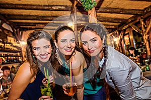 Young beautiful women with cocktails in bar or club
