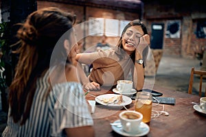 Young beautiful women having coffee and feeling joyful in cafe