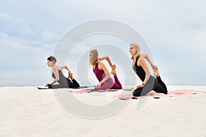 Young beautiful women perform yoga exercises