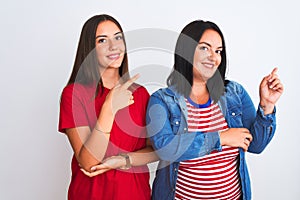 Young beautiful women wearing casual clothes standing over isolated white background with a big smile on face, pointing with hand