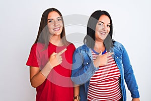 Young beautiful women wearing casual clothes standing over isolated white background cheerful with a smile on face pointing with