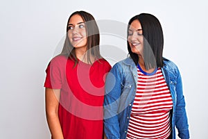 Young beautiful women wearing casual clothes standing over isolated white background looking away to side with smile on face,