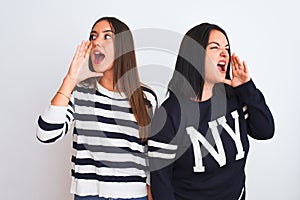 Young beautiful women wearing casual clothes standing over isolated white background shouting and screaming loud to side with hand