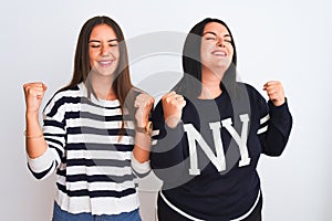 Young beautiful women wearing casual clothes standing over isolated white background very happy and excited doing winner gesture