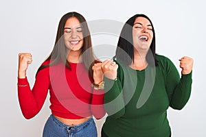 Young beautiful women wearing casual clothes standing over isolated white background very happy and excited doing winner gesture