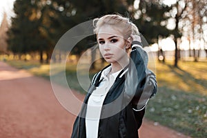 Young beautiful young blond woman with brown eyes in a stylish white shirt in a fashionable light black jacket
