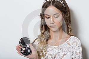 Young beautiful young girl with long curly hair, no makeup with a clean face with a wreath on his head portrait in the studio on a