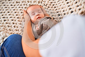 Young beautifull woman and her baby on the sofa over blanket at home