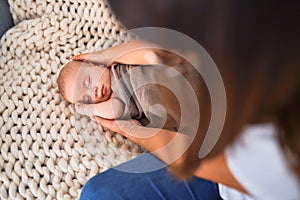 Young beautifull woman and her baby on the sofa over blanket at home