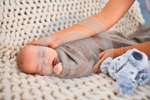 Young beautifull woman and her baby on the sofa over blanket at home