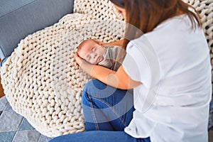 Young beautifull woman and her baby on the sofa over blanket at home