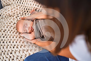 Young beautifull woman and her baby on the sofa over blanket at home