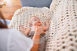 Young beautifull woman and her baby on the sofa over blanket at home