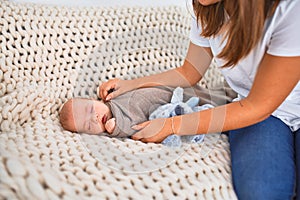 Young beautifull woman and her baby on the sofa over blanket at home