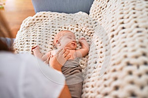 Young beautifull woman and her baby on the sofa over blanket at home