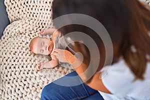 Young beautifull woman and her baby on the sofa over blanket at home