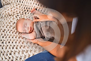 Young beautifull woman and her baby on the sofa over blanket at home