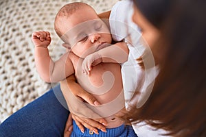 Young beautifull woman and her baby on the sofa over blanket at home