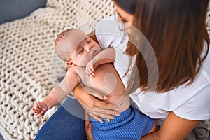 Young beautifull woman and her baby on the sofa over blanket at home