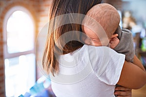 Young beautifull woman and her baby standing on the floor at home