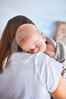 Young beautifull woman and her baby standing on the floor at home