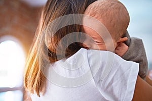 Young beautifull woman and her baby standing on the floor at home