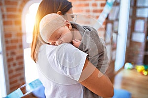 Young beautifull woman and her baby standing on the floor at home