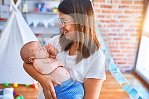 Young beautifull woman and her baby standing on the floor at home