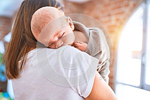 Young beautifull woman and her baby standing on the floor at home