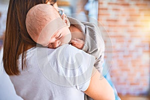 Young beautifull woman and her baby standing on the floor at home