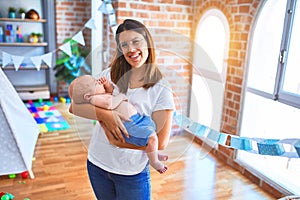 Young beautifull woman and her baby standing on the floor at home