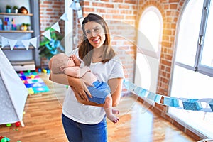 Young beautifull woman and her baby standing on the floor at home photo