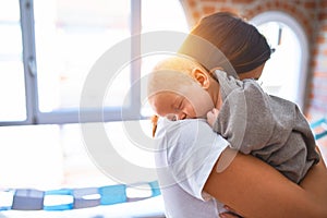 Young beautifull woman and her baby standing on the floor at home photo