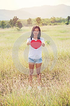 Young beauty asia woman in white shirt relaxing smile hold red heart on hand