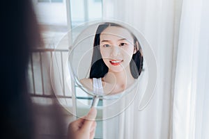 Young Beauty Asian Woman Looking at Mirror Check Clear Face