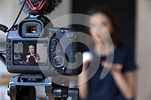 Young beauty blogger girl recording video on dslr camera