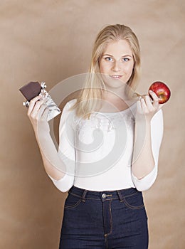 Young beauty blond teenage girl eating chocolate