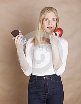 Young beauty blond teenage girl eating chocolate