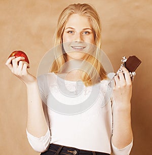 Young beauty blond teenage girl eating chocolate