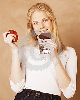 Young beauty blond teenage girl eating chocolate