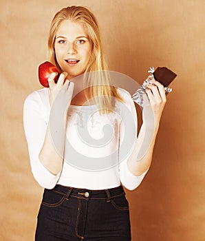 Young beauty blond teenage girl eating chocolate smiling, choice