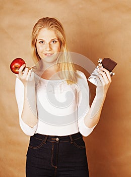 Young beauty blond teenage girl eating chocolate smiling, choice